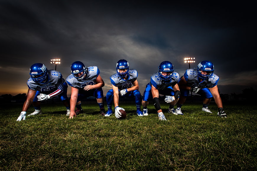 American football team lineup on field at dusk