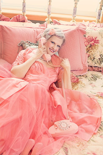 Vintage Woman in Pink Gown Talking on Retro Rotary Phone in Bed