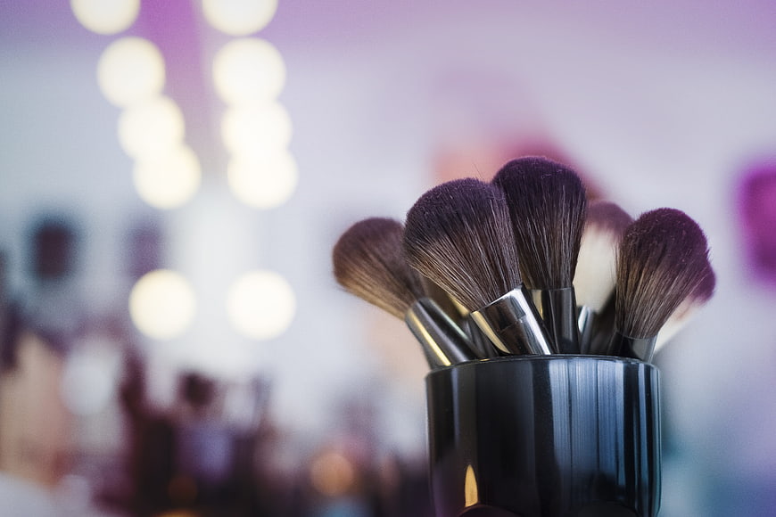 Makeup Brushes in Black Holder with Blurred Vanity Lights