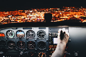 Pilot Hand on Yoke in Airplane Cockpit at Night