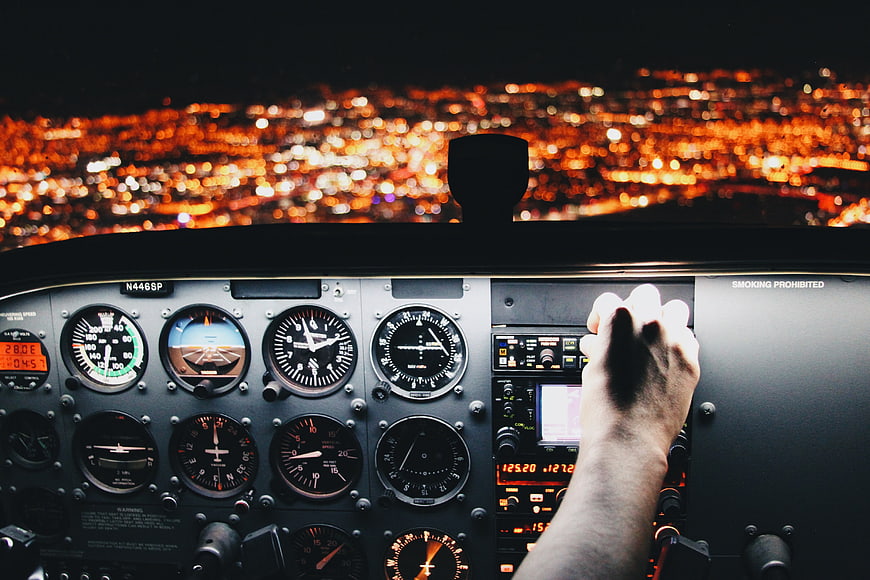 Pilot Hand on Yoke in Airplane Cockpit at Night