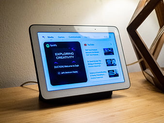 Smart Display Showing Spotify and YouTube Podcasts on Wooden Desk