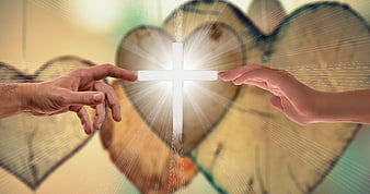 Two hands reaching toward glowing cross with heart background