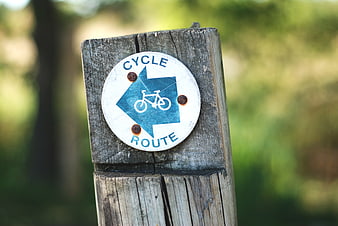 Blue Cycle Route Sign on Weathered Wooden Post