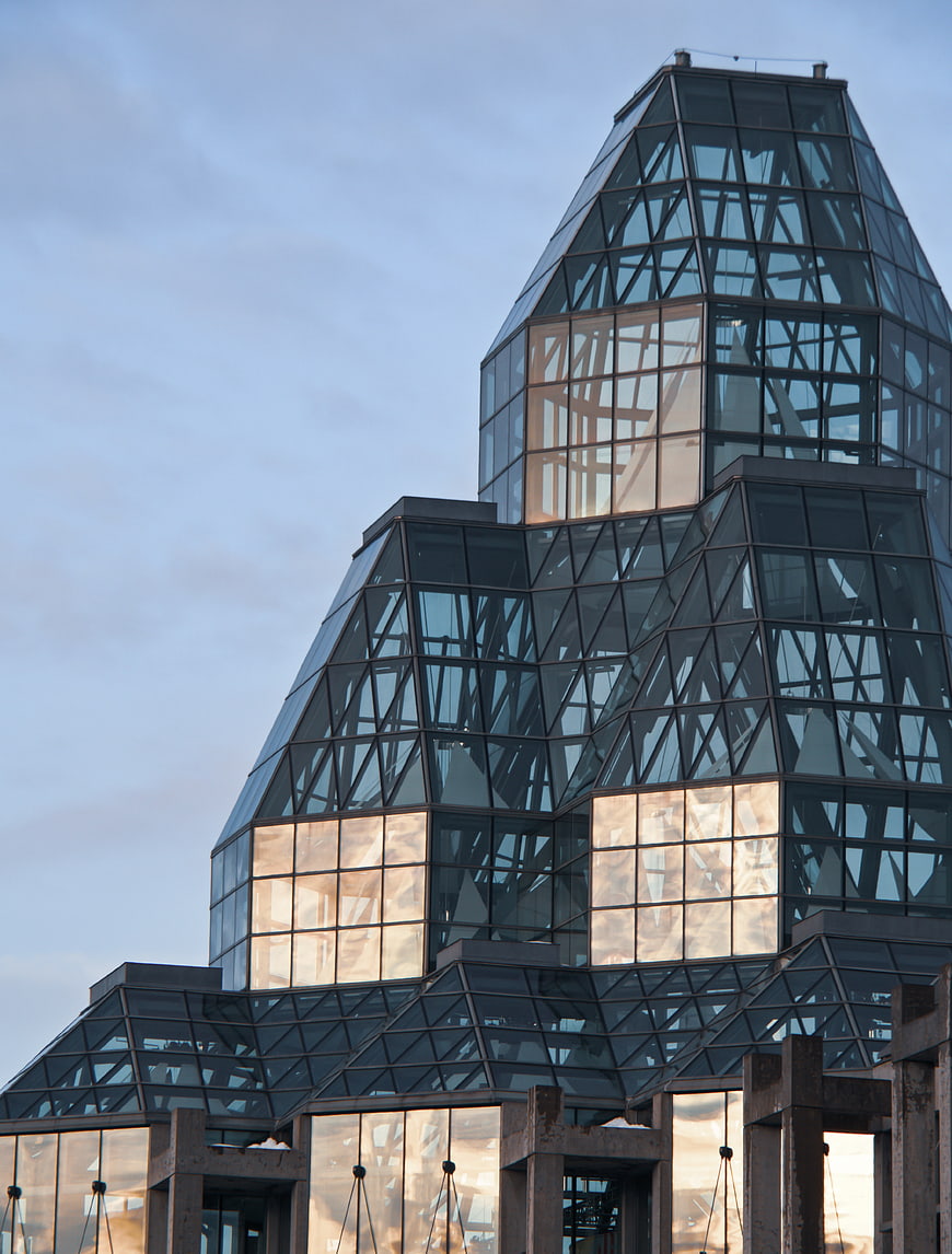 Modern Glass Architecture with Geometric Facade and Sunset Reflections