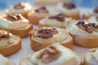 Close-up of walnut and cheese bruschetta on wooden board