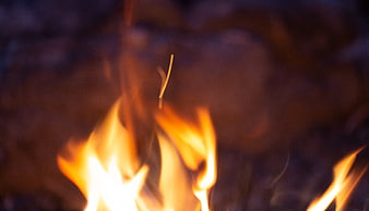 Close-up of flickering campfire flames and sparks at night
