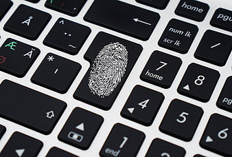 Fingerprint on laptop keyboard key symbolizing digital security
