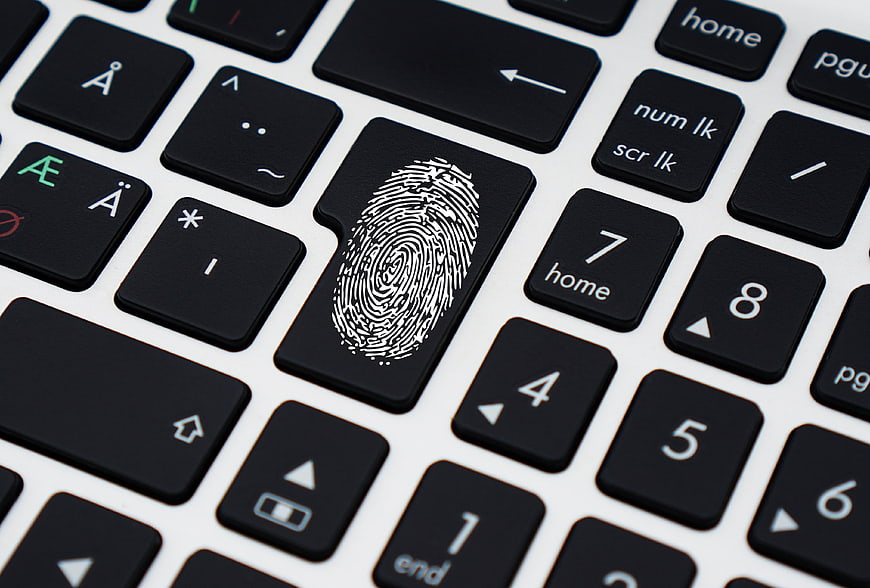 Fingerprint on laptop keyboard key symbolizing digital security