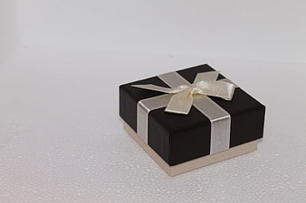 Black gift box with silver ribbon on white background