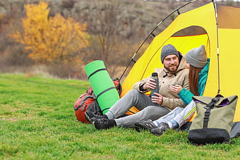 Happy couple camping with tent in autumn forest