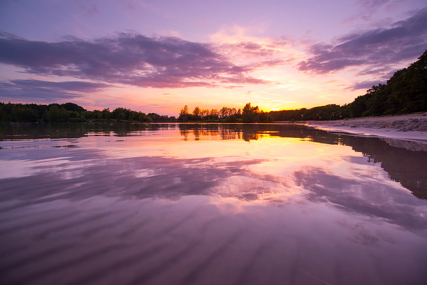 Serene Sunset Reflection on Calm River Water