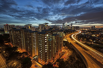 Kuala Lumpur skyline at dusk with light trails on highway