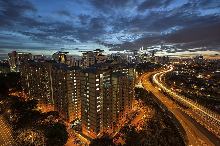 Kuala Lumpur skyline at dusk with light trails on highway