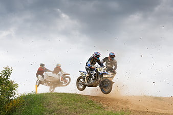 Sidecar motocross riders kicking up dust on a dirt track