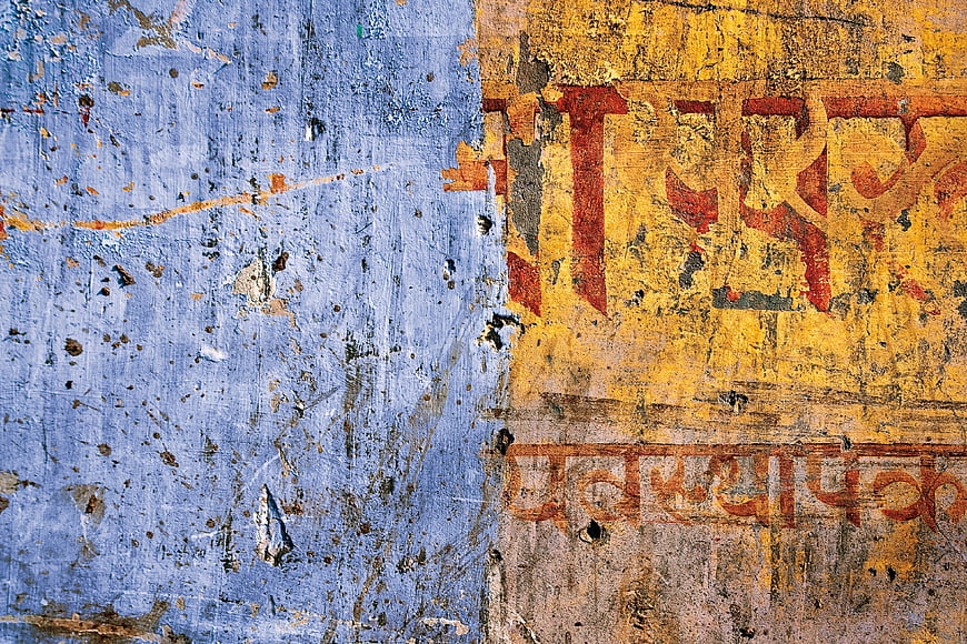 Textured Blue and Yellow Wall with Faded Hindi Text