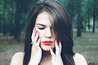 Close-up portrait of woman with red lipstick in forest