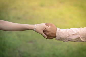 Couple Holding Hands in Green Field