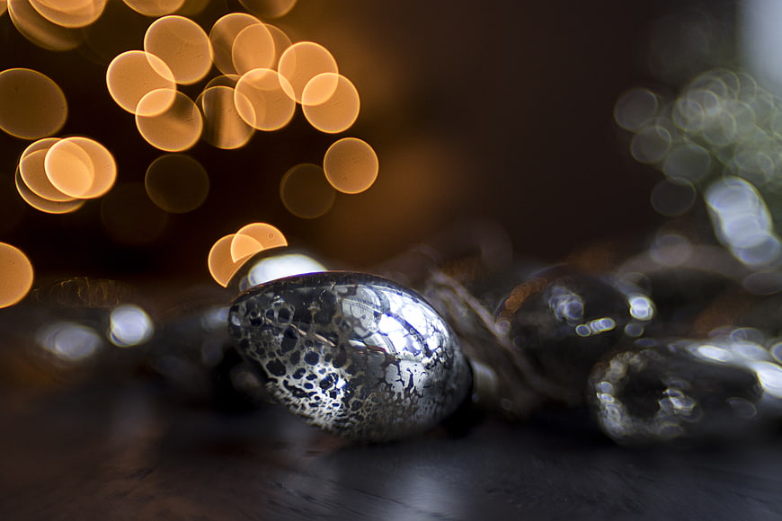 Close-up of silver Christmas ornament with bokeh lights