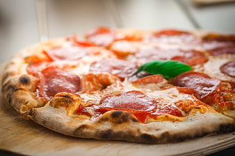 Close-up of freshly baked pepperoni pizza on wooden board