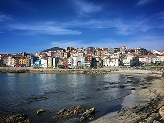 Colorful coastal town on sunny beach with blue sky