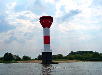 Red and white navigation beacon in river water