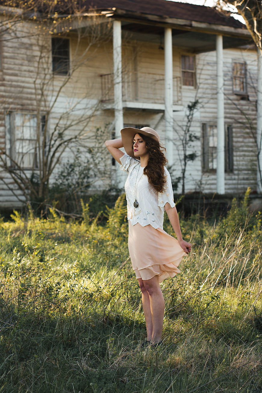 Woman in Vintage Dress Standing in Front of Old House