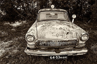Front view of abandoned vintage Soviet car in forest