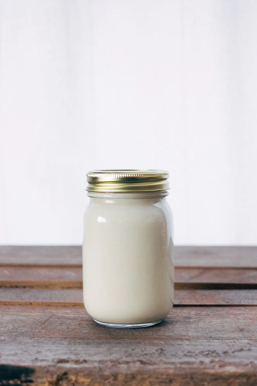 Glass Jar of White Cream on Rustic Wooden Table