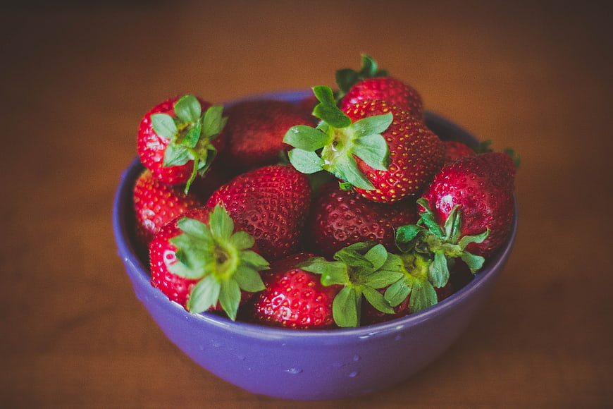 Fresh Red Strawberries in a Purple Bowl on Wooden Table