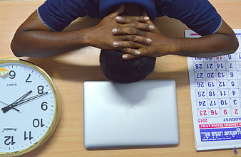 Stressed Person Head On Desk With Laptop, Clock, And Calendar