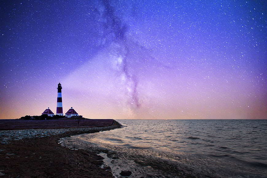 Lighthouse on Coast Under Milky Way Night Sky