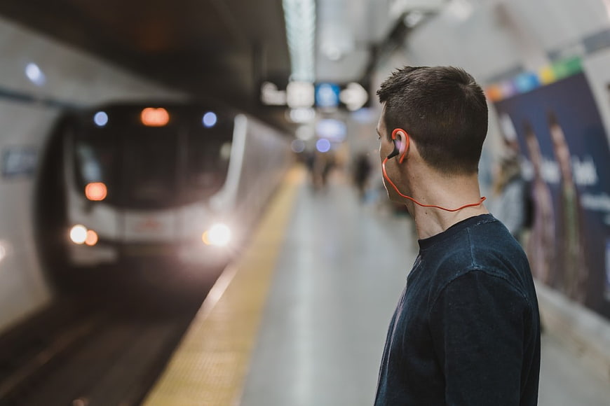 Man with Orange Headphones Waiting for Subway Train