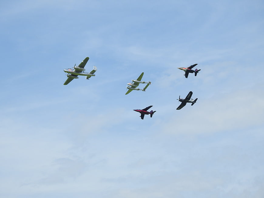 Vintage Military Aircraft Flying in Formation Against Blue Sky