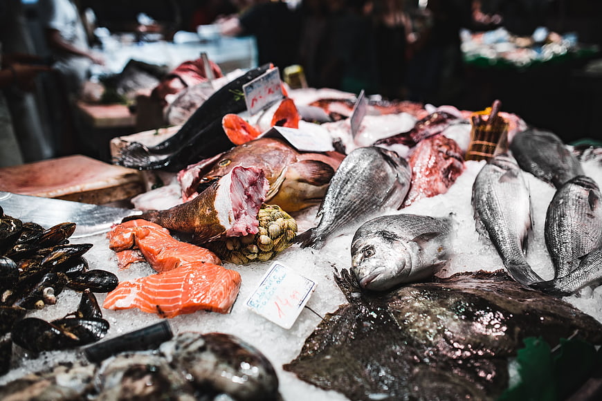 Fresh seafood display on ice at a bustling fish market