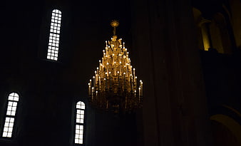 Ornate Golden Chandelier in Dark Cathedral Interior
