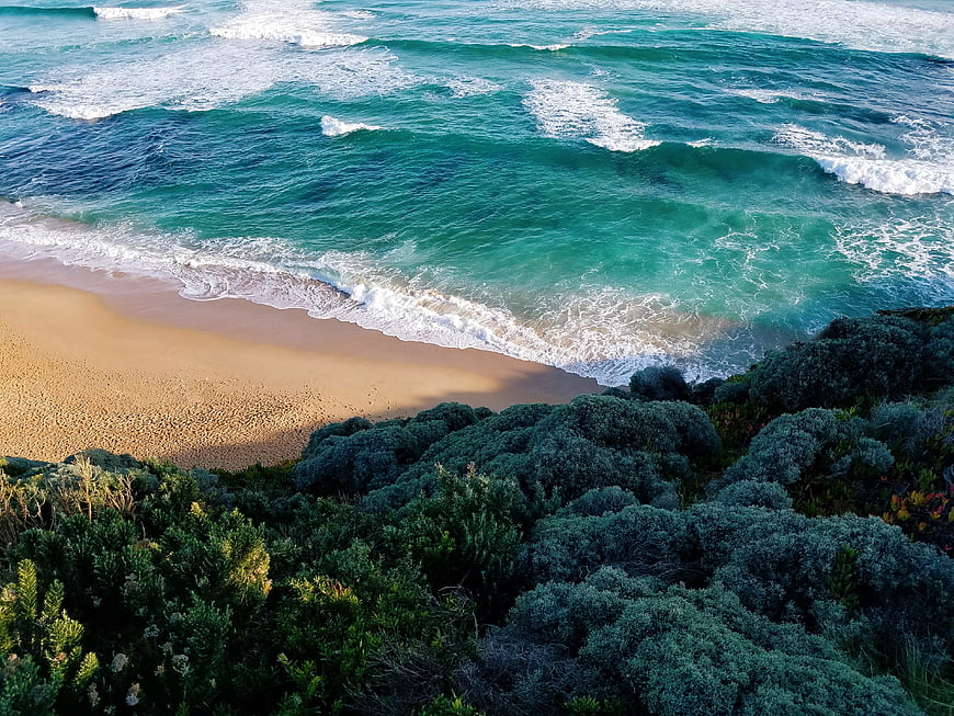 Aerial View of Turquoise Ocean Waves Crashing on Sandy Beach