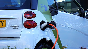 White Electric Car Charging with Orange Cable