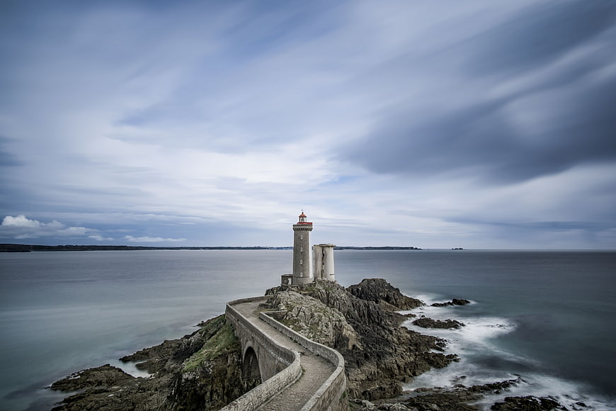 Dramatic Lighthouse on Rocky Coast with Long Exposure Sea