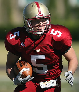 American Football Player in Red Jersey Running with Ball