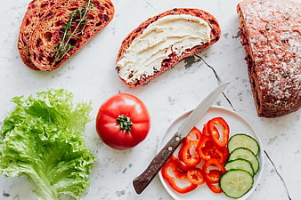 Flat lay of cranberry bread, hummus, and fresh vegetables