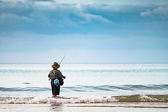 Woman Fishing Alone on Beach Shoreline