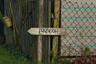 Rustic wooden sign reading Hochzeit on a garden fence