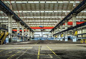 Empty industrial factory hall with overhead crane and concrete floor