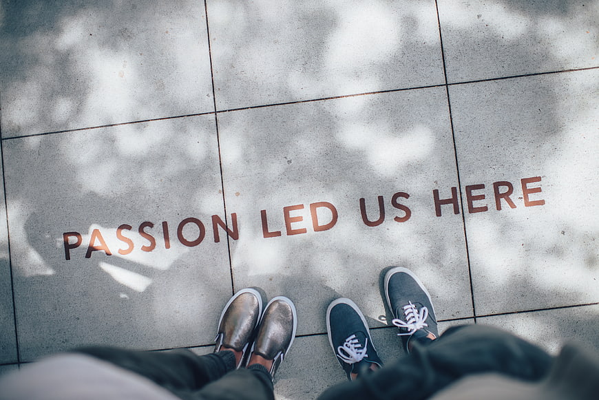 Couple standing on pavement with passion quote