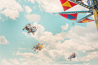 People riding a swing ride at a summer amusement park