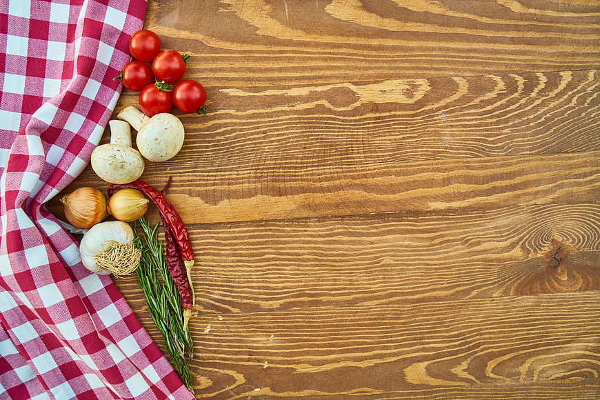 Fresh Vegetables and Herbs on Wooden Table with Red Checkered Cloth