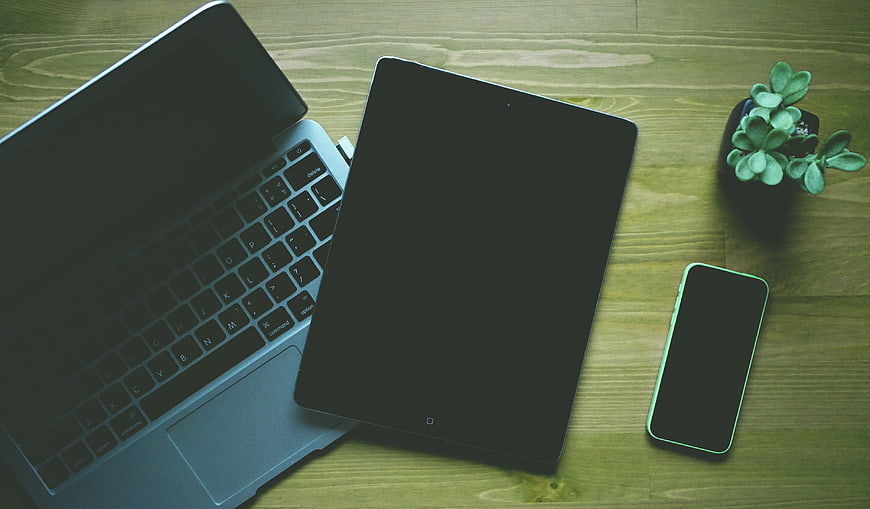 Top View of Laptop, Tablet, and Smartphone on Wooden Desk