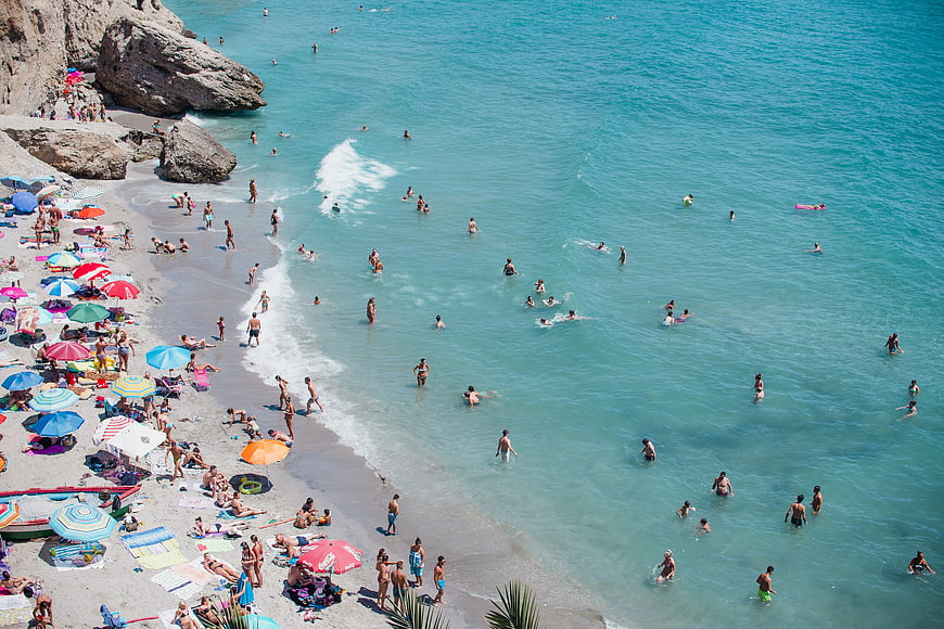 Aerial View of Crowded Beach with Turquoise Water and Colorful Umbrellas