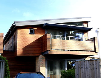 Modern two-story house with wooden cladding and balcony